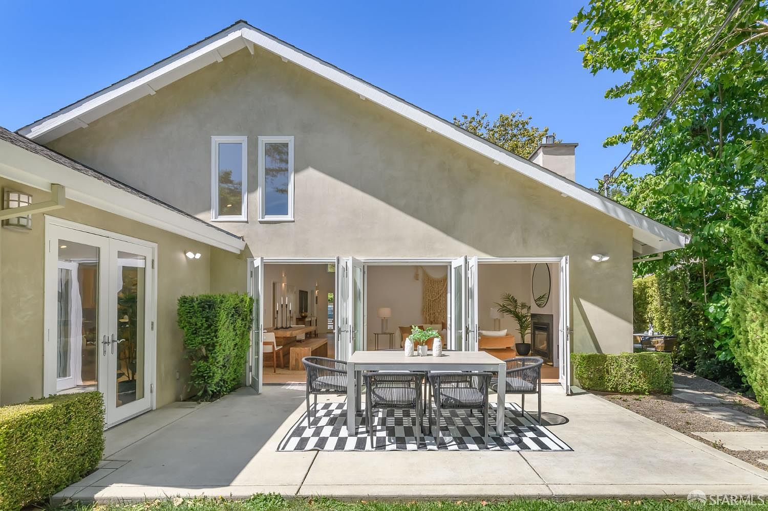 Rear elevation with full-height bi-fold glass doors opening from the great room to a covered garden patio