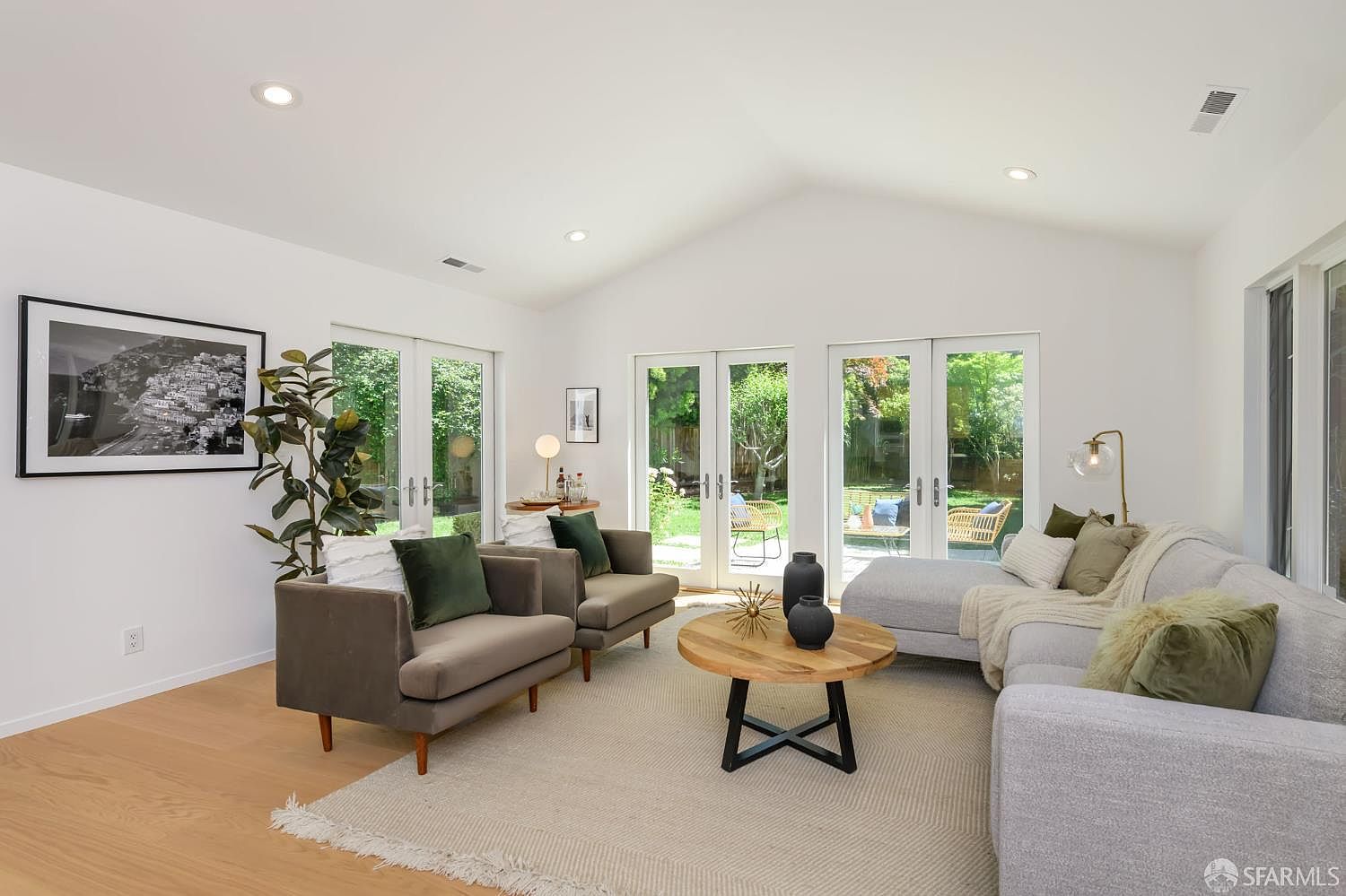 Family room with vaulted ceiling, French doors to garden, and curated mid-century furnishings