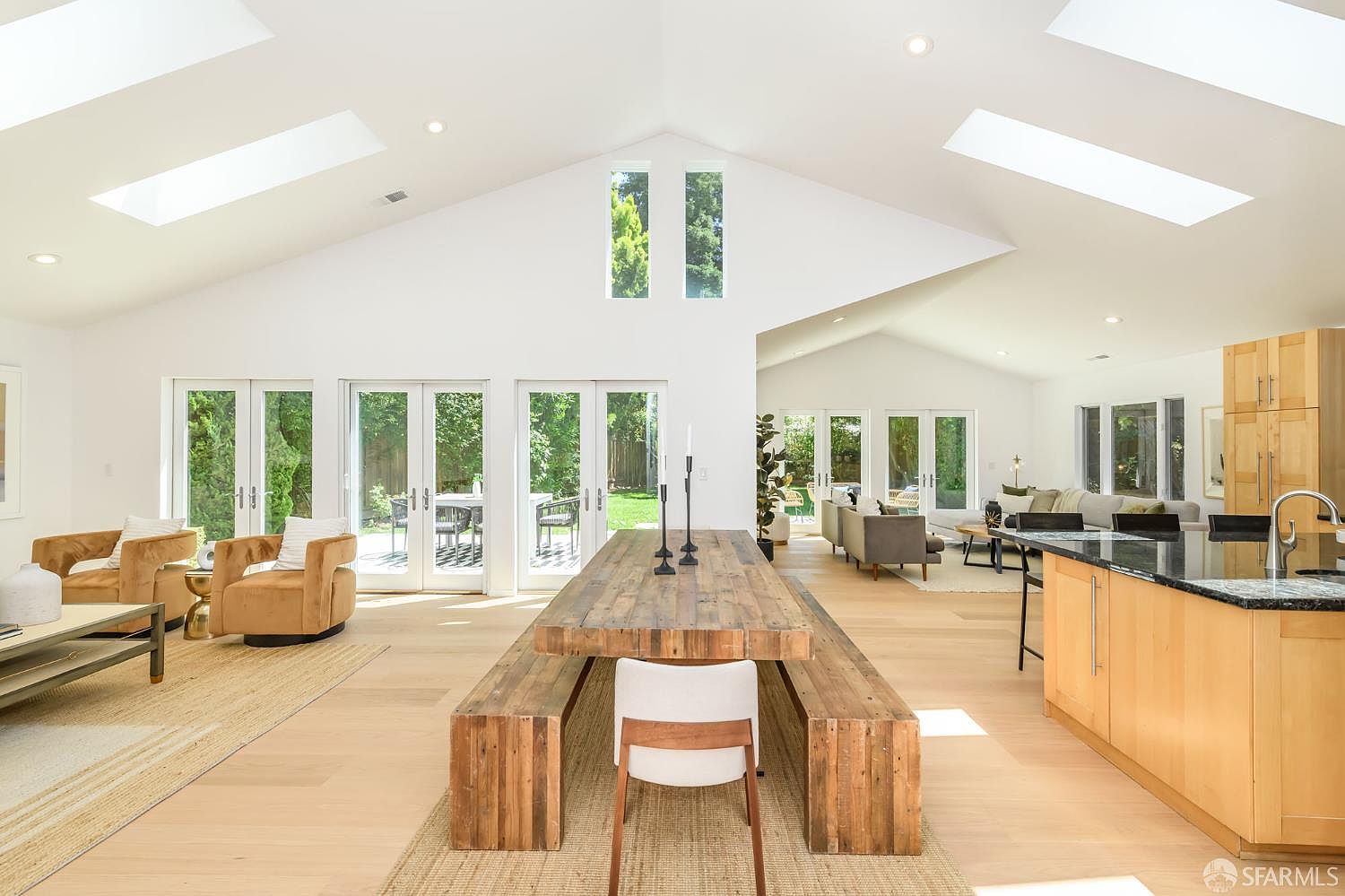 A 40-foot vaulted Great Room with skylights, French doors opening to the garden, and a walnut farm table down the center